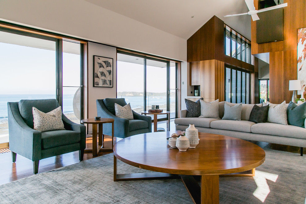 Großes, Offenes Modernes Wohnzimmer mit weißer Wandfarbe, braunem Holzboden und braunem Boden in Melbourne