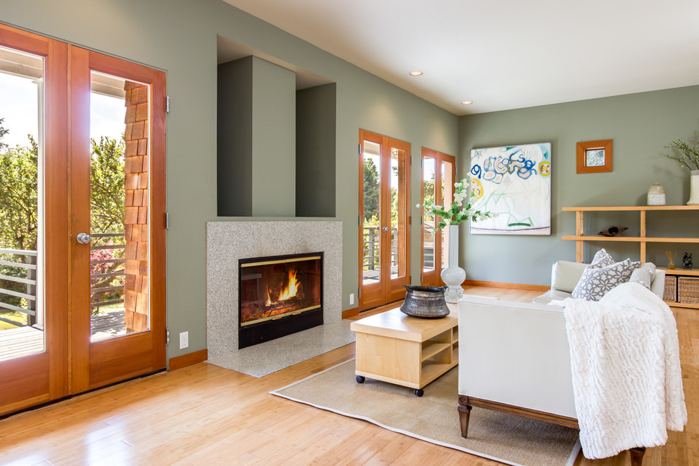 Réalisation d'un grand salon design ouvert avec un mur vert, parquet clair, une cheminée standard et un manteau de cheminée en pierre.