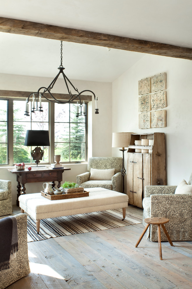 Imagen de salón abierto rural sin televisor y chimenea con paredes blancas y suelo de madera en tonos medios