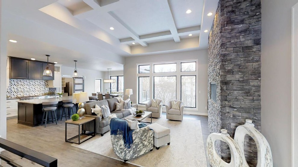 На фото: большая открытая гостиная комната в классическом стиле с стандартным камином, фасадом камина из камня и телевизором на стене с