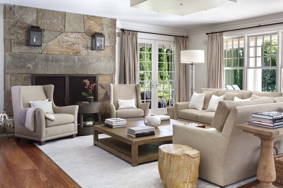 Стильный дизайн: гостиная комната в классическом стиле с белыми стенами, паркетным полом среднего тона, стандартным камином, фасадом камина из камня и коричневым полом - последний тренд