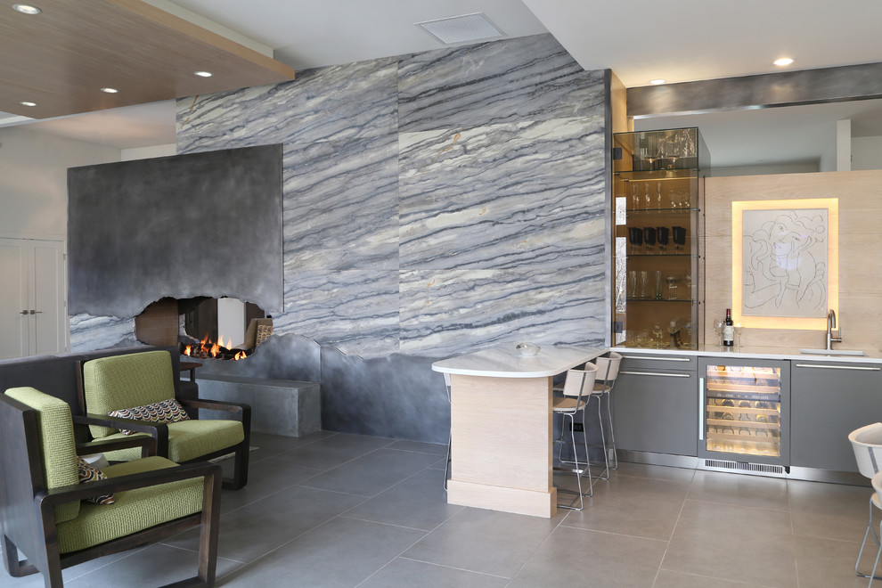 Inspiration pour un grand salon design ouvert avec un bar de salon, un mur blanc, un sol en carrelage de céramique, une cheminée double-face, un manteau de cheminée en métal, un téléviseur encastré et un sol gris.