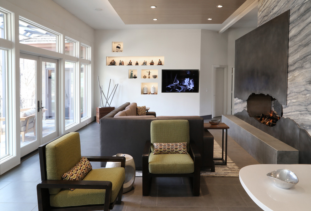 This is an example of a large contemporary open plan living room in Boise with a home bar, white walls, ceramic flooring, a two-sided fireplace, a metal fireplace surround, a built-in media unit and grey floors.