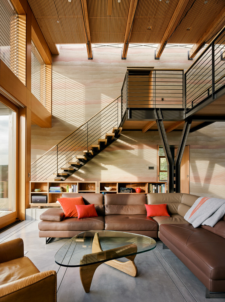Idée de décoration pour un salon design ouvert avec sol en béton ciré et un escalier.