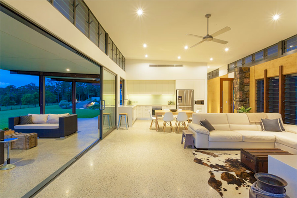 Geräumiges, Offenes Modernes Wohnzimmer mit beiger Wandfarbe, Betonboden, Kamin, Kaminumrandung aus Stein und TV-Wand in Brisbane