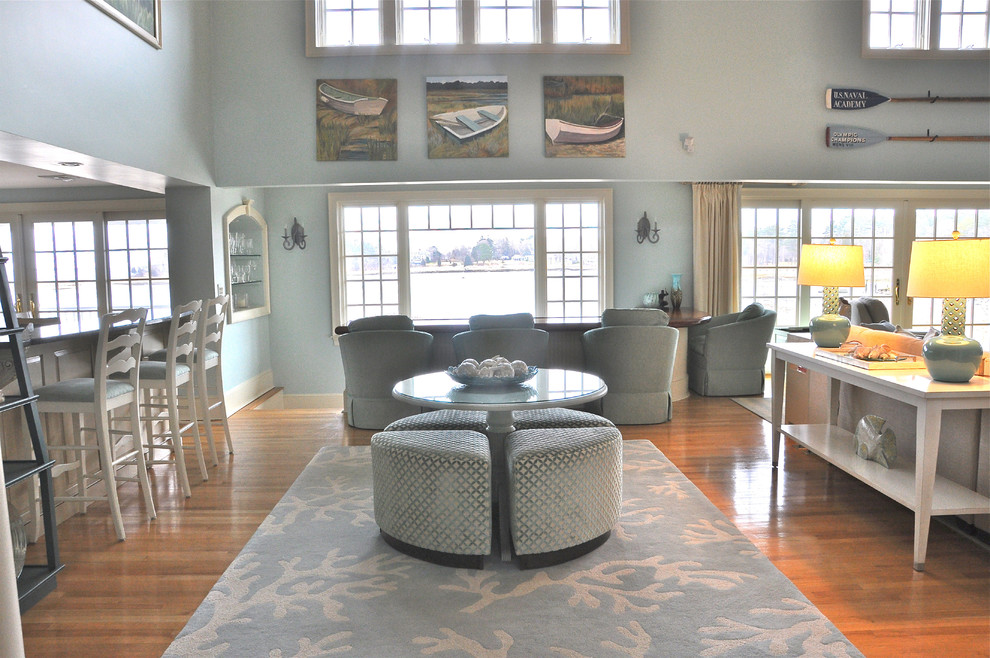 Exemple d'un grand salon bord de mer ouvert avec une salle de réception, un mur bleu, un sol en bois brun et aucune cheminée.