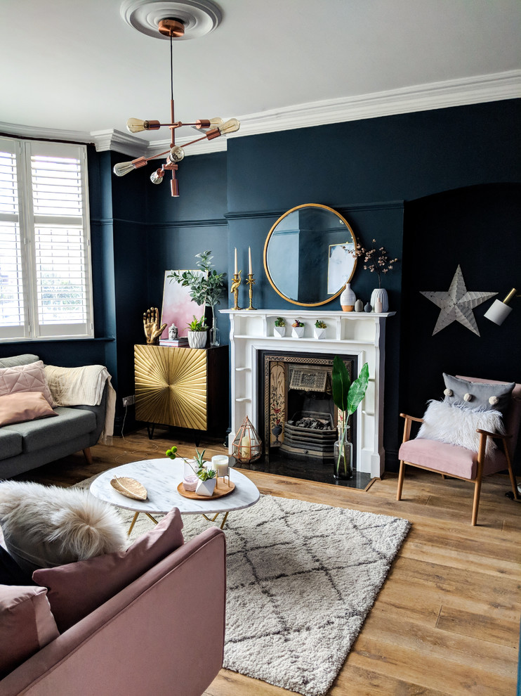 Aménagement d'un salon éclectique fermé avec un mur bleu, parquet clair, une cheminée standard et un sol beige.