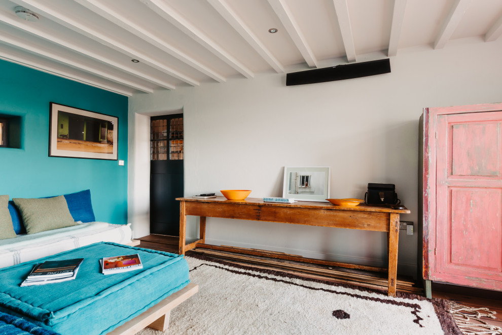 This is an example of a medium sized beach style enclosed living room in Cornwall with blue walls and medium hardwood flooring.
