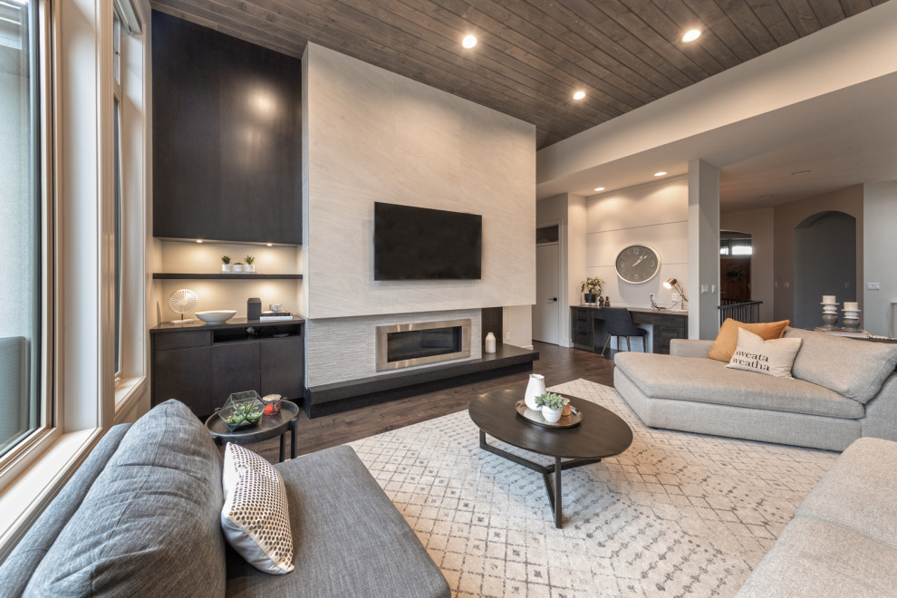 Inspiration for a large contemporary open plan living room in Edmonton with grey walls, dark hardwood flooring, a standard fireplace, a tiled fireplace surround, a wall mounted tv, brown floors, a timber clad ceiling and panelled walls.
