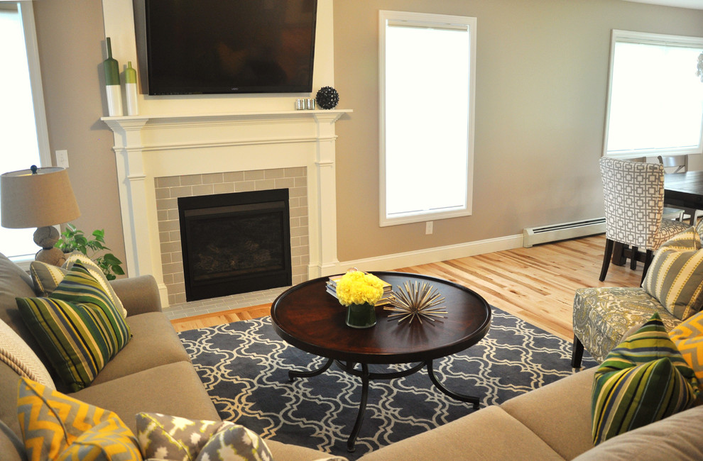 Photo of a medium sized traditional open plan living room in Burlington with grey walls, light hardwood flooring, a standard fireplace, a tiled fireplace surround and a wall mounted tv.