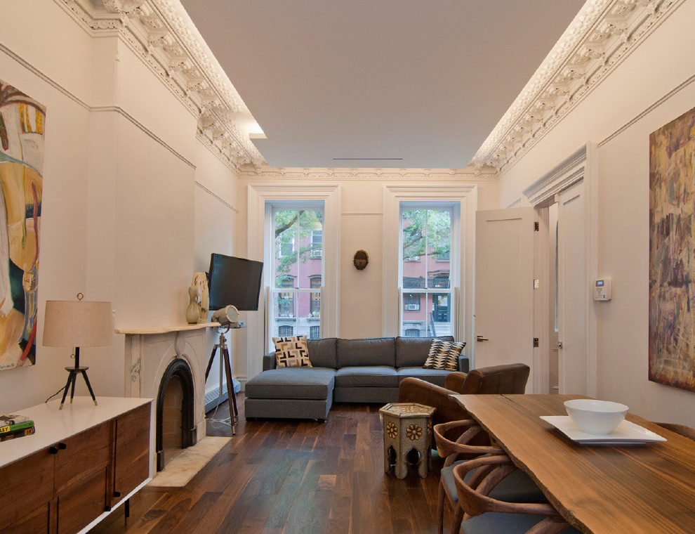 Пример оригинального дизайна: гостиная комната в стиле неоклассика (современная классика) с белыми стенами и синим диваном