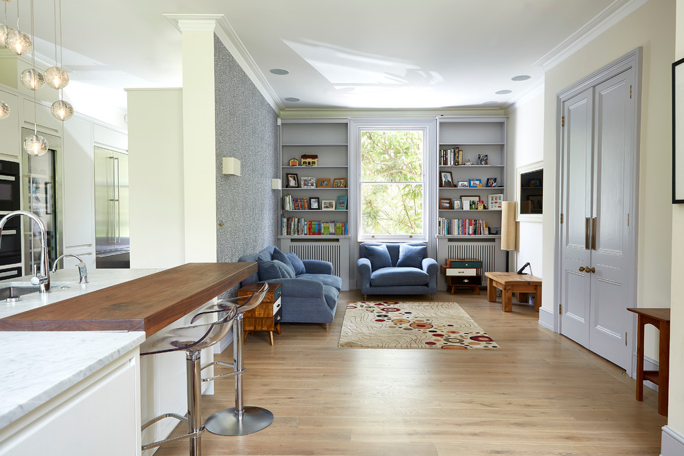 На фото: гостиная комната в стиле неоклассика (современная классика) с синим диваном