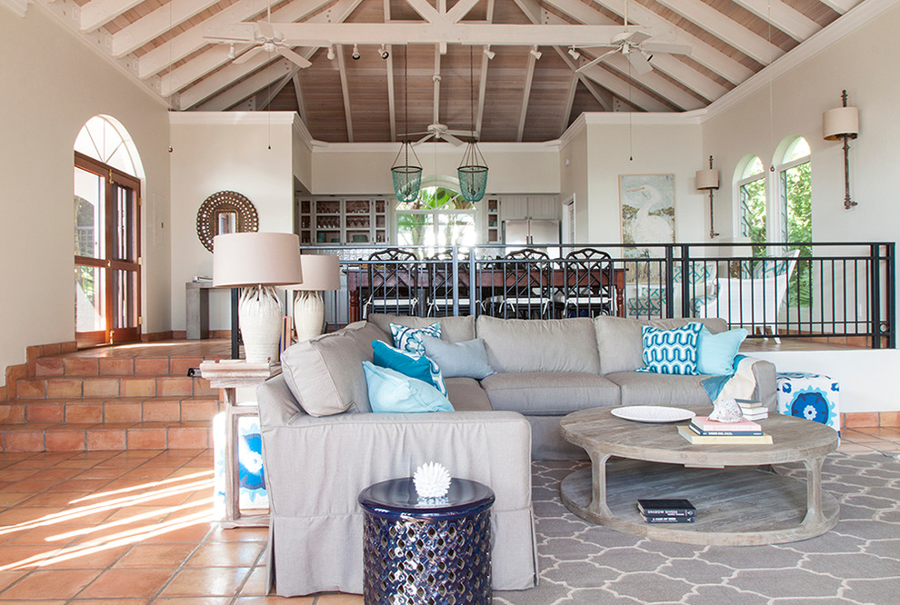 Large world-inspired formal open plan living room in Other with white walls, terracotta flooring, no tv, a vaulted ceiling and orange floors.