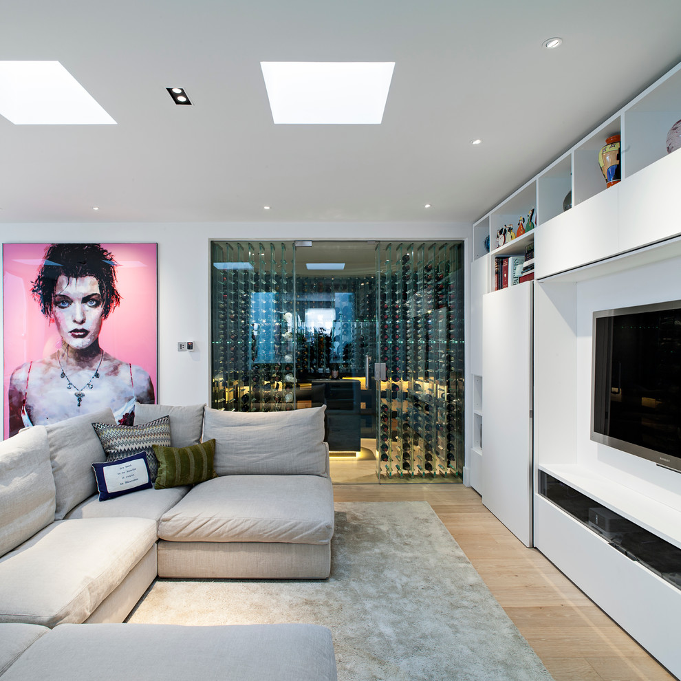 Cette photo montre un salon tendance avec un mur blanc, parquet clair et un téléviseur fixé au mur.