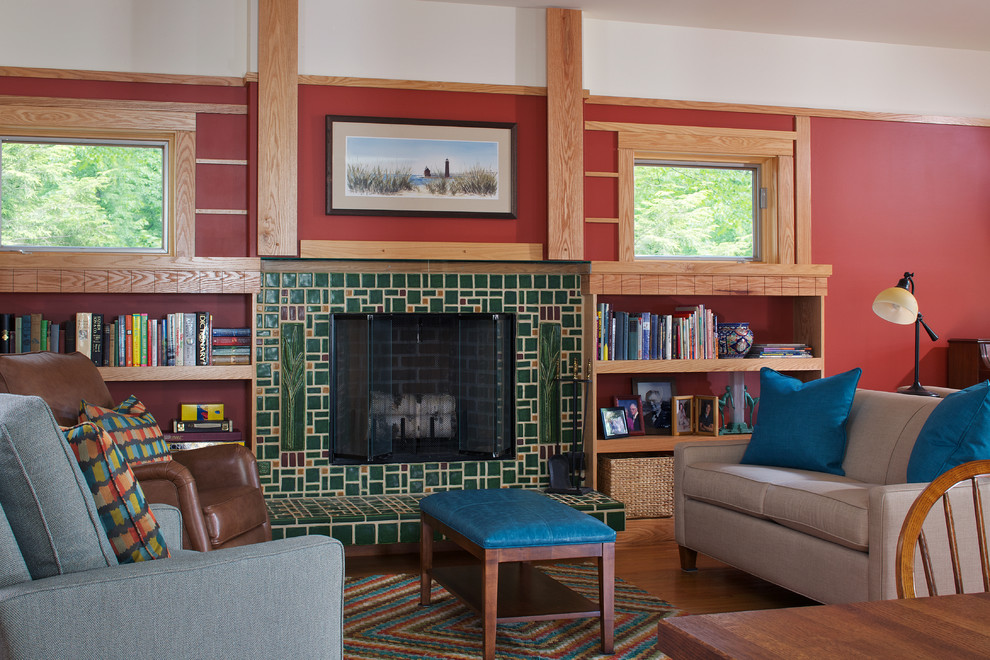 Foto de biblioteca en casa de estilo americano con paredes rojas, suelo de madera en tonos medios y todas las chimeneas