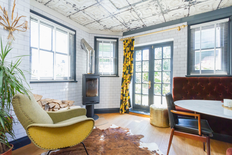 Industrial Wohnzimmer mit hellem Holzboden, Kaminofen und weißer Wandfarbe in Sussex