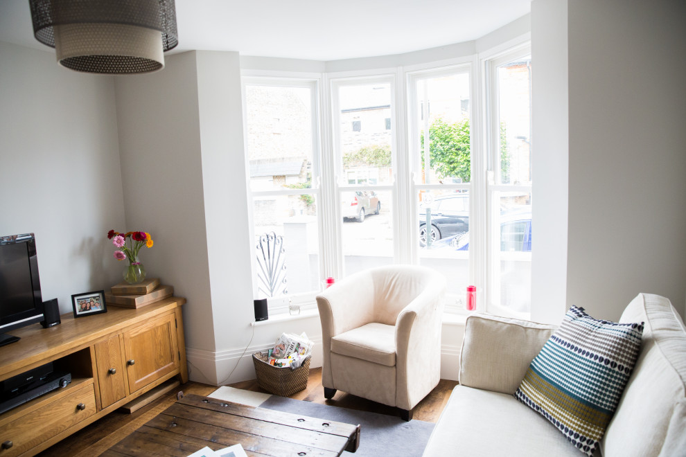 Kleines, Repräsentatives, Abgetrenntes Modernes Wohnzimmer mit grauer Wandfarbe, dunklem Holzboden, freistehendem TV und braunem Boden in London