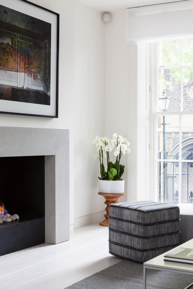 ロンドンにあるラグジュアリーな中くらいなコンテンポラリースタイルのおしゃれなリビング (白い壁、淡色無垢フローリング、標準型暖炉、石材の暖炉まわり、テレビなし) の写真