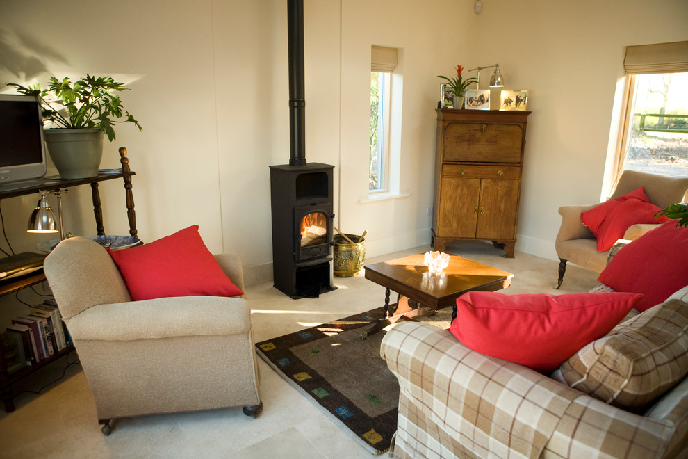 Ejemplo de salón para visitas abierto de estilo de casa de campo con paredes blancas, suelo de piedra caliza, estufa de leña y televisor independiente