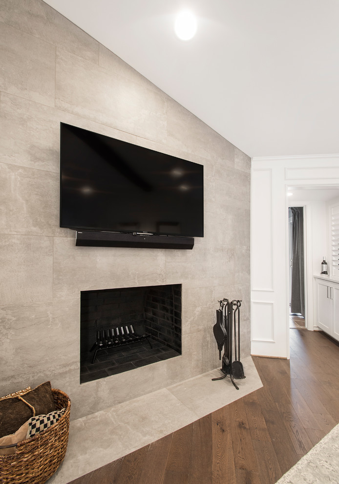 Inredning av ett klassiskt mellanstort separat vardagsrum, med vita väggar, ljust trägolv, en standard öppen spis, en spiselkrans i trä, en väggmonterad TV och brunt golv
