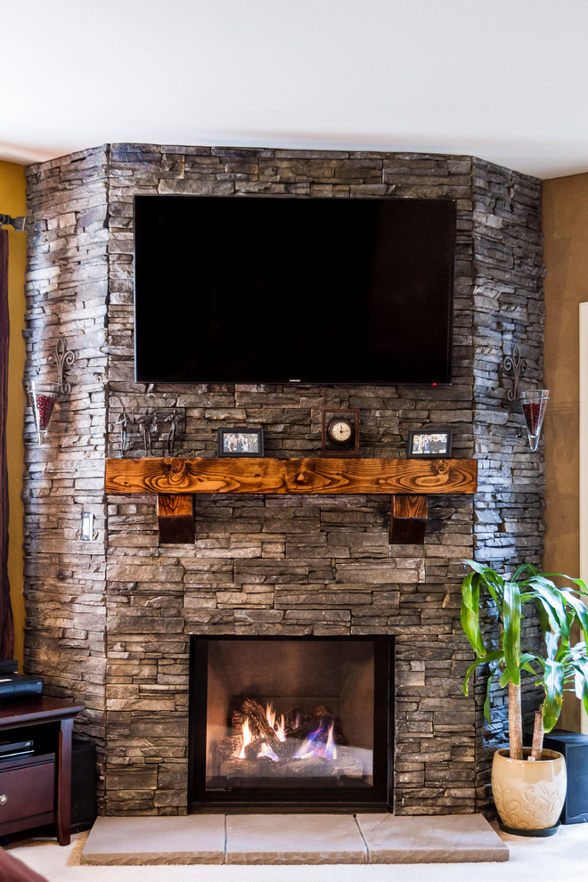 シアトルにある中くらいなコンテンポラリースタイルのおしゃれなリビング (ベージュの壁、カーペット敷き、標準型暖炉、石材の暖炉まわり、壁掛け型テレビ) の写真