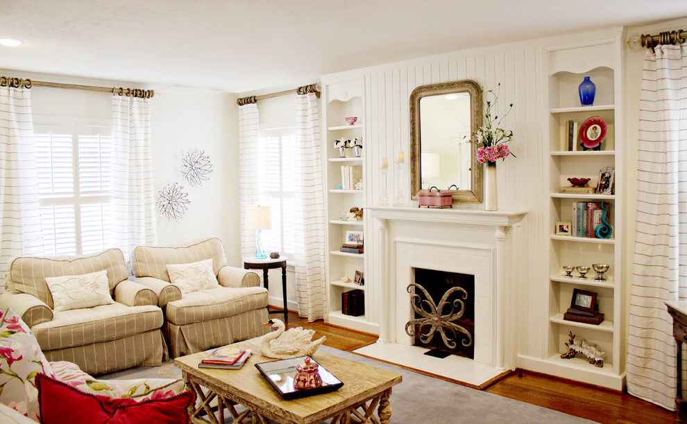 Example of a classic medium tone wood floor living room design in Dallas with white walls and a standard fireplace