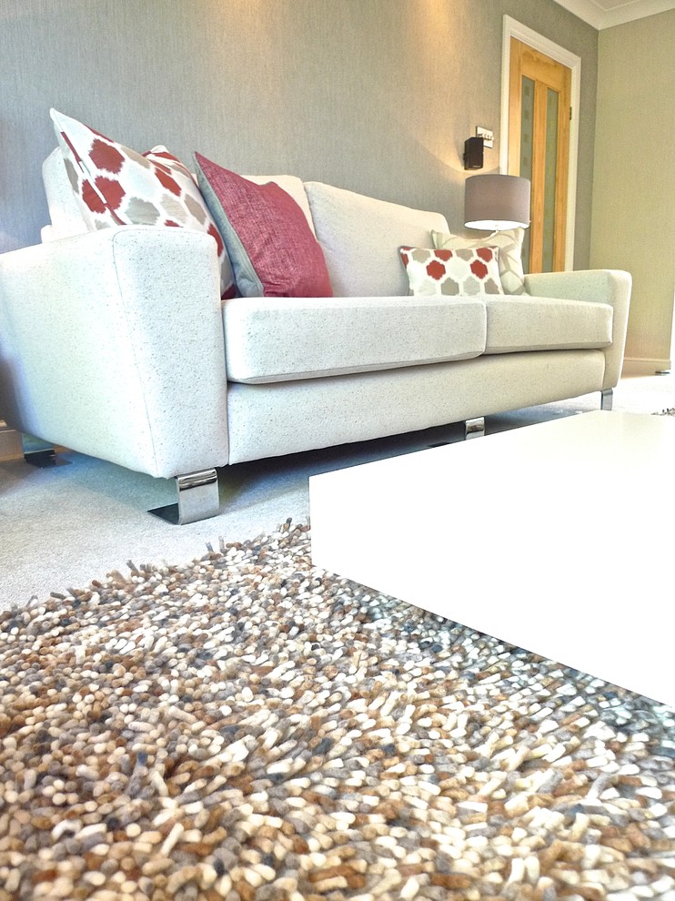 Photo of a large modern living room in West Midlands with beige walls, carpet, a ribbon fireplace, a plastered fireplace surround, a built-in media unit and beige floors.