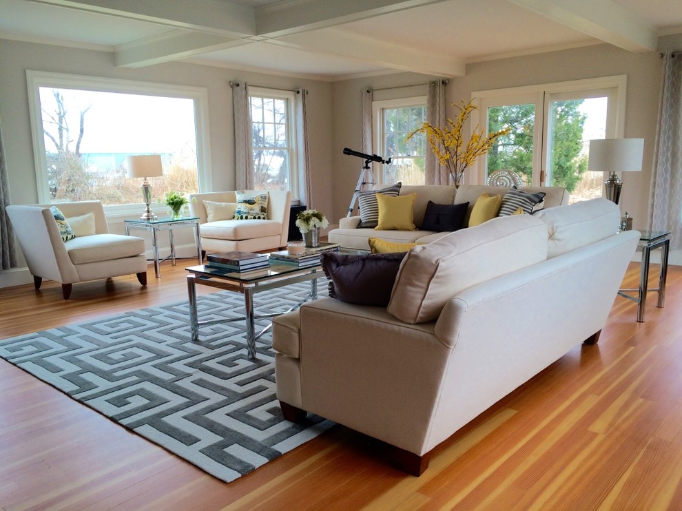 Ejemplo de salón abierto costero de tamaño medio sin chimenea y televisor con paredes beige, suelo de madera clara y suelo marrón