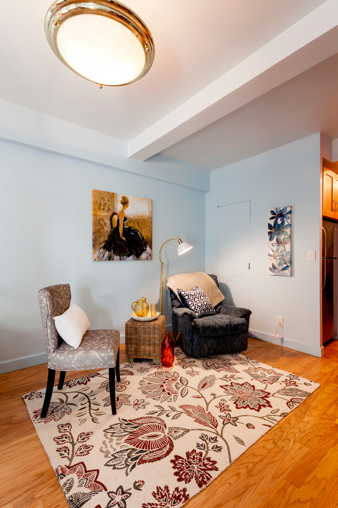 Foto de salón abierto ecléctico pequeño sin chimenea y televisor con paredes azules y suelo de madera clara