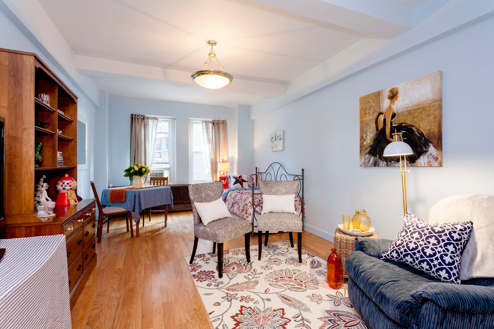 Foto de salón abierto ecléctico pequeño sin chimenea y televisor con paredes azules y suelo de madera clara