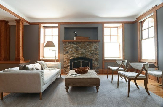 Immagine di un soggiorno classico di medie dimensioni e aperto con pareti grigie, parquet chiaro, camino classico e cornice del camino in pietra