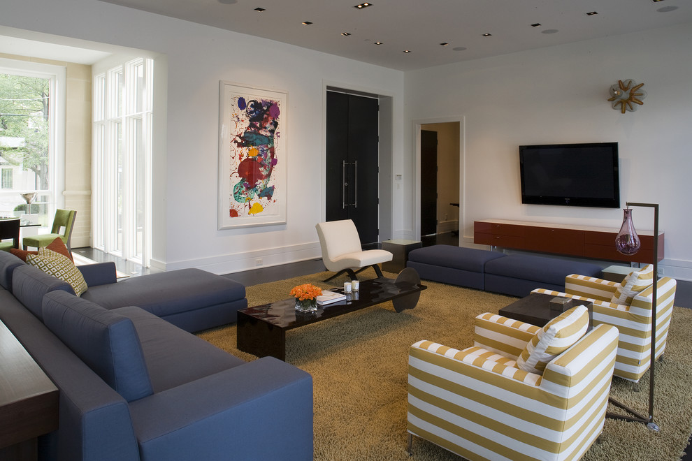 Diseño de salón abierto actual de tamaño medio sin chimenea con paredes blancas, televisor colgado en la pared y moqueta