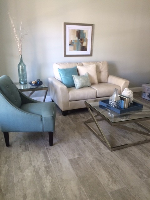 This is an example of a small contemporary enclosed living room in Tampa with grey walls, light hardwood flooring and no fireplace.