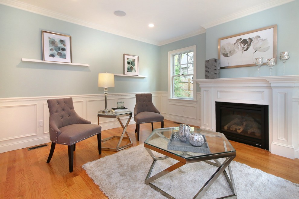 Ispirazione per un soggiorno classico con sala formale, pareti blu, pavimento in legno massello medio e camino classico