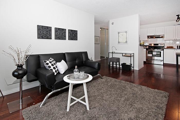 Esempio di un piccolo soggiorno design aperto con pareti bianche, pavimento in legno massello medio, nessun camino e nessuna TV
