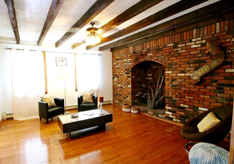 Modelo de salón cerrado romántico de tamaño medio con paredes blancas, suelo de madera en tonos medios, todas las chimeneas y marco de chimenea de ladrillo