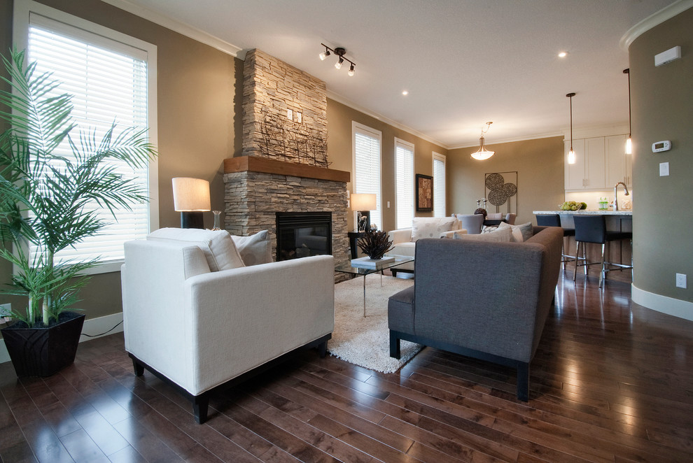 Großes, Repräsentatives, Fernseherloses, Offenes Modernes Wohnzimmer ohne Kamin mit blauer Wandfarbe, braunem Holzboden und Kaminumrandung aus Beton in Calgary