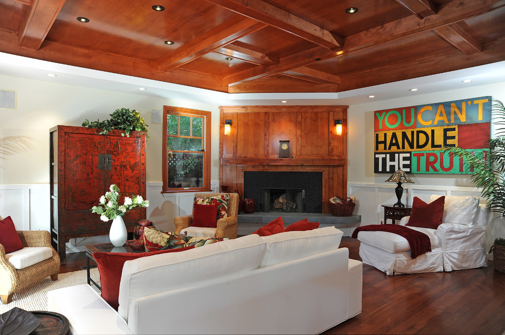 Foto di un soggiorno classico con pareti beige, pavimento in legno massello medio e camino ad angolo