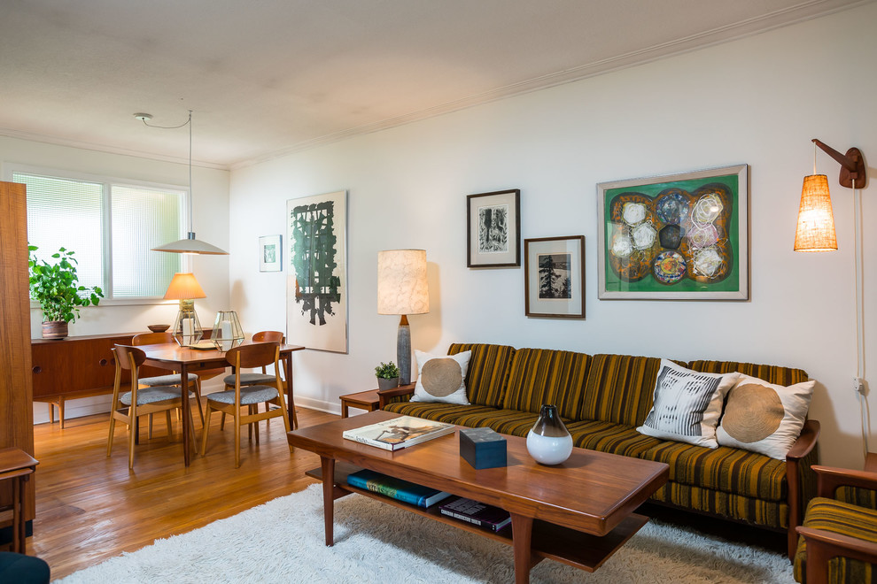 Inspiration for a 1960s medium tone wood floor and brown floor living room remodel in Toronto with white walls