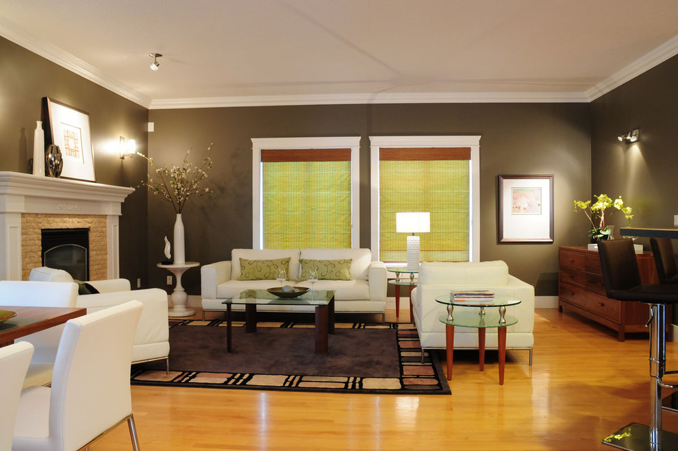 Immagine di un grande soggiorno contemporaneo con pareti marroni, parquet chiaro, camino classico e cornice del camino in mattoni