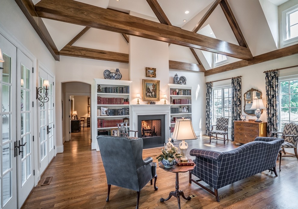 Country medium tone wood floor and brown floor living room photo in Atlanta with white walls and a standard fireplace