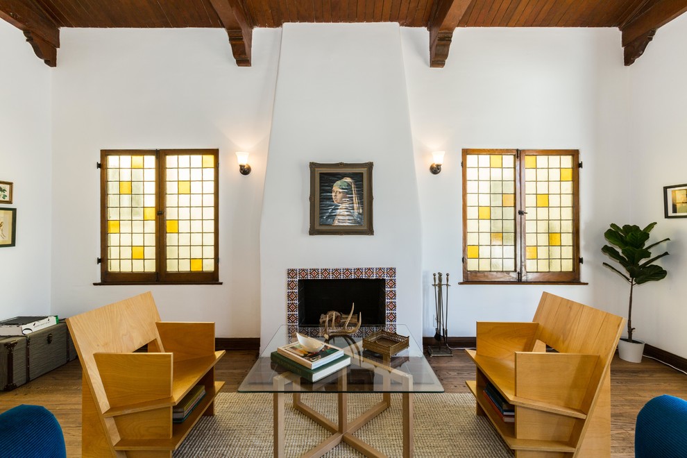Repräsentatives Mediterranes Wohnzimmer mit weißer Wandfarbe, braunem Holzboden und Kamin in Los Angeles