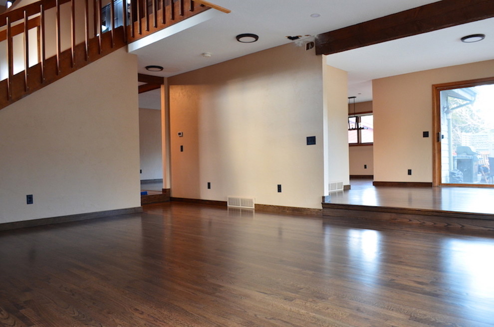 Идея дизайна: большая двухуровневая гостиная комната в современном стиле с бежевыми стенами, паркетным полом среднего тона, печью-буржуйкой, коричневым полом и фасадом камина из дерева
