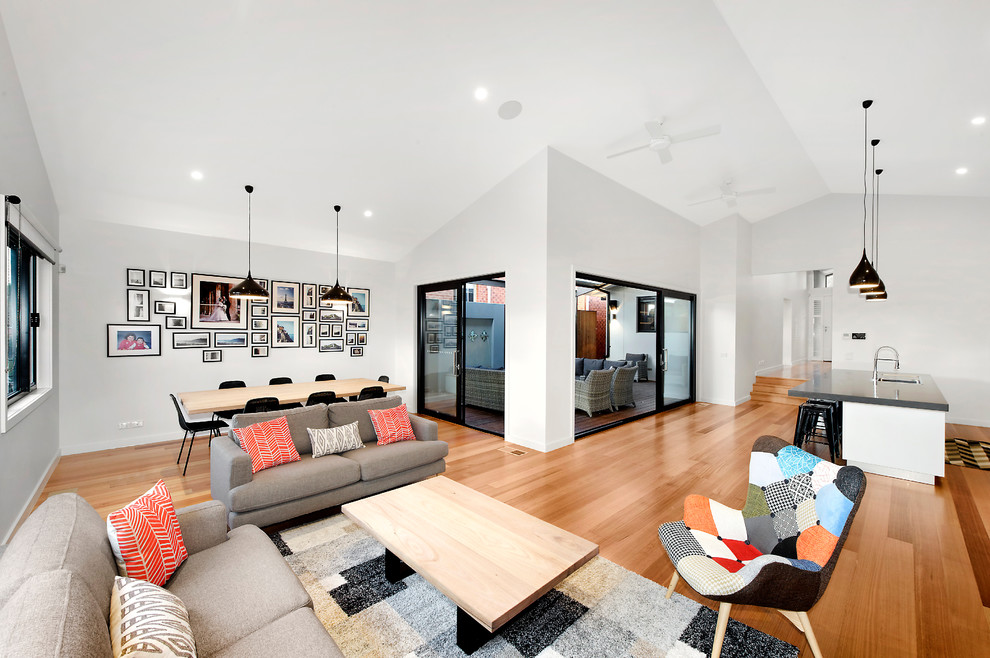 Großes, Fernseherloses, Offenes Modernes Wohnzimmer mit weißer Wandfarbe, hellem Holzboden, Kamin und Kaminumrandung aus Metall in Melbourne