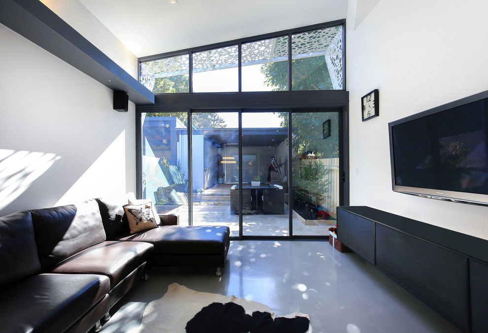 Mittelgroßes, Offenes Modernes Wohnzimmer mit weißer Wandfarbe, Betonboden, TV-Wand und grauem Boden in Sydney
