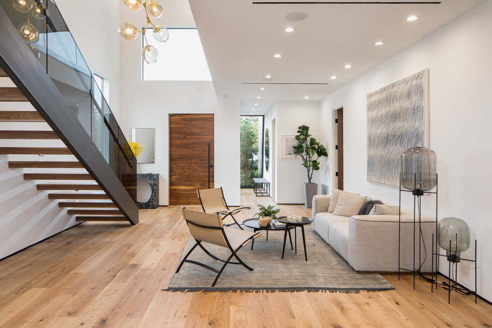 Idee per un grande soggiorno design aperto con pareti bianche, parquet chiaro e pavimento beige