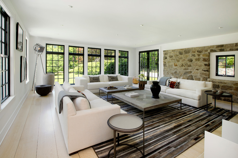Exemple d'un salon nature de taille moyenne avec une salle de réception, un mur blanc, parquet clair, une cheminée standard, un manteau de cheminée en pierre et un sol beige.