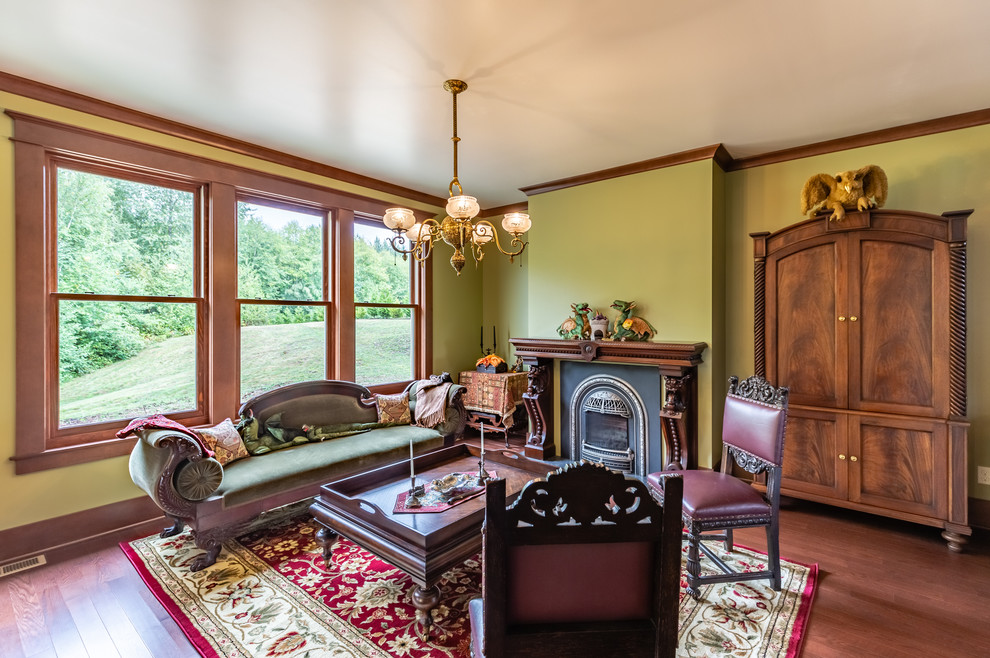 Großes Klassisches Wohnzimmer mit grüner Wandfarbe, braunem Holzboden, Kamin und braunem Boden in Seattle