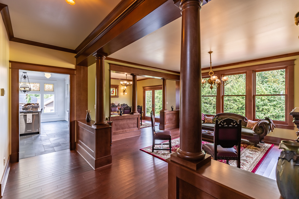 Источник вдохновения для домашнего уюта: большая гостиная комната в викторианском стиле с зелеными стенами, темным паркетным полом, стандартным камином, фасадом камина из дерева и коричневым полом