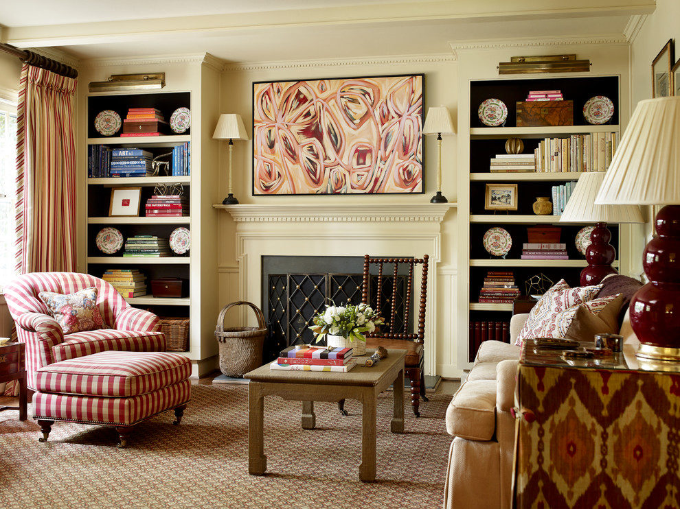 Inspiration for a mid-sized timeless carpeted living room library remodel in Charlotte with beige walls, a standard fireplace, a concealed tv and a wood fireplace surround